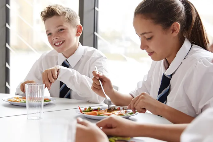 students in uniforms eating